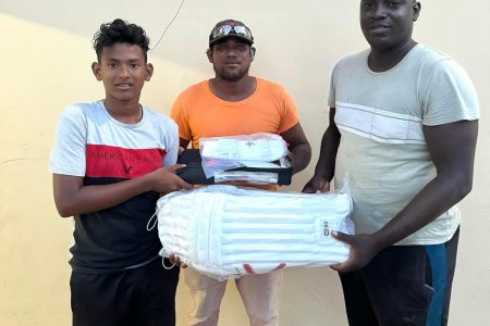National U-15 player Gilbert Griffith Jr. (left) receiving the equipment from a member of the Tucber Park Cricket Club of New Amsterdam, Berbice

