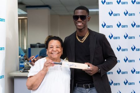  The Guyana Bank for Trade and Industry (GBTI) said that its Water Street Branch came alive on Thursday as it hosted rising Guyanese cricket star, Shamar Joseph, as its  way of celebrating him. Lucky customers and visitors scored themselves a  piece of history with a bowler-autographed bat to cherish. This GBTI photo shows Shamar Joseph and one of the lucky customers.