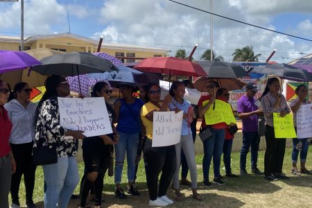 Teachers holding placards in front of the Anna Regina Town Council building 