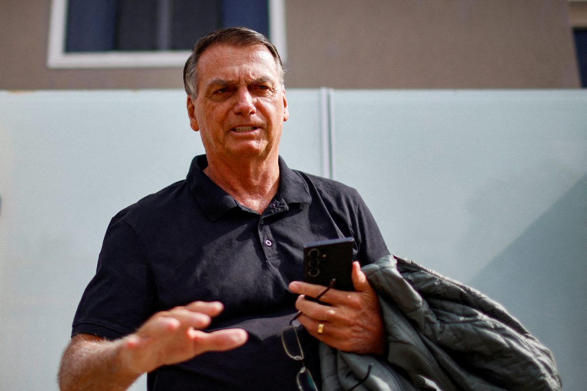 FILE PHOTO: Former Brazilian President Jair Bolsonaro gestures while standing in front of his house before testifying to the Federal Police in Brasilia, Brazil, February 22, 2024. REUTERS/Adriano Machado/File Photo