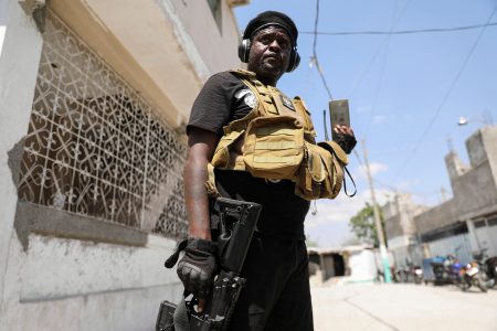 FILE PHOTO: Former police officer Jimmy "Barbecue" Cherizier, and leader of an alliance of armed groups, speaks to a news outlet on a mobile phone during a news conference, in Port-au-Prince, Haiti, March 11, 2024. REUTERS/Ralph Tedy Erol/File Photo