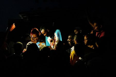 FILE PHOTO: People try to get a once-monthly ration of chicken, during a blackout, at a small state-run market in Santiago, Cuba, March 20, 2024. REUTERS/Alexandre Meneghini/File Photo