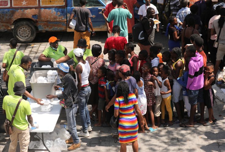 Residents who fled violence gather to receive meals at a school being used as shelter as the government declared state of emergency amid violence, in Port-au-Prince, Haiti, March 4, 2024. REUTERS/Ralph Tedy Erol