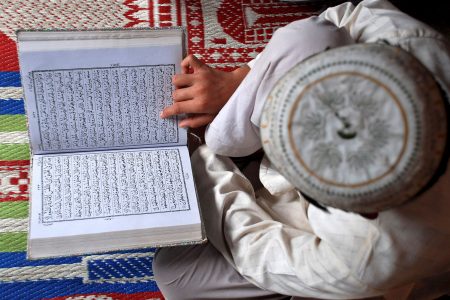 FILE PHOTO: A Muslim boy reads the Koran at a madrasa or religious school on the first day of the holy month of Ramadan in the northern Indian city of Mathura August 23, 2009. REUTERS/K. K. Arora/File Photo