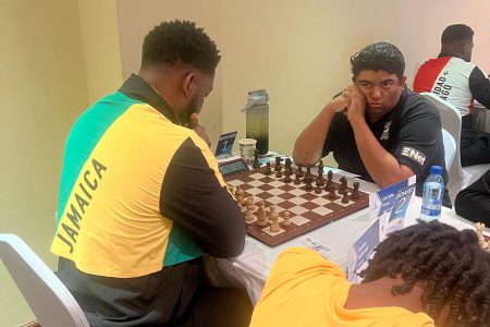 Guyana’s Candidate Master Taffin Khan (right) awaits his opponent’s (Jamaica’s Nathan Hinds) move