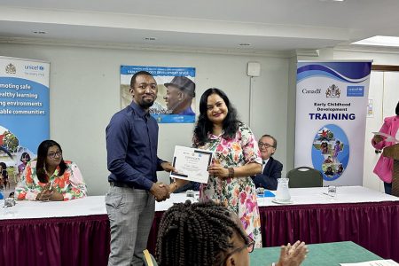 Registration and Licensing Officer in Region 10, Duanne McFarlane, receives certificate from Minister of Human Services and Social Security, Dr Vindhya Persaud 