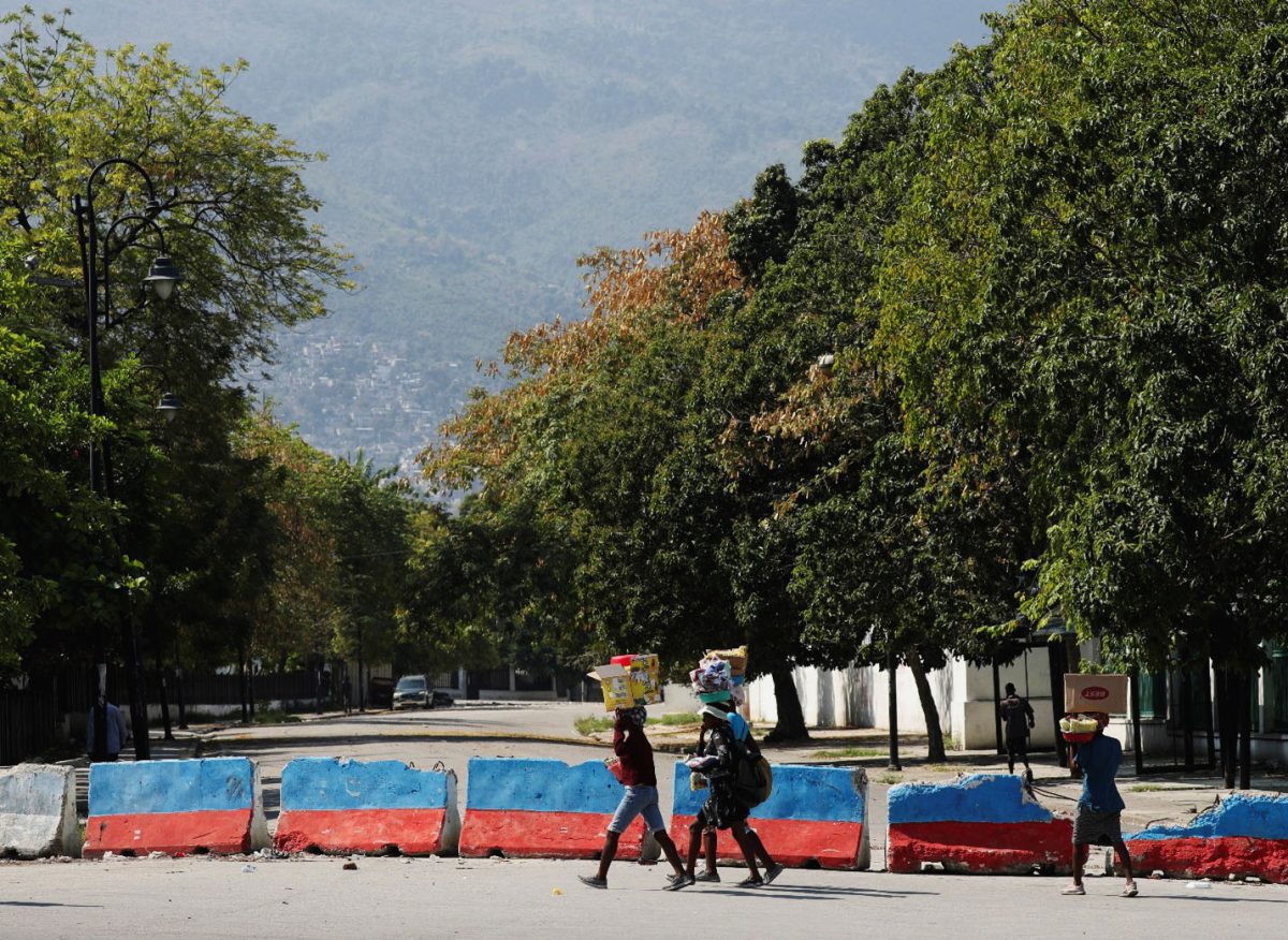 Street vendors carry goods for sale as they walk near the Presidential Palace after Haiti’s Prime Minister Ariel Henry pledged to step down following months of escalating gang violence, in Port-au-Prince, Haiti March 12, 2024. REUTERS/Ralph Tedy Erol