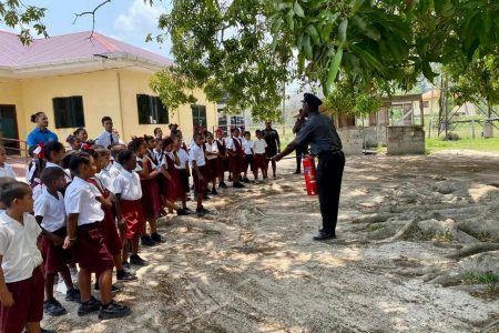 A Guyana Fire Service rank instructing the pupils of Hururu Primary in fire safety awareness 