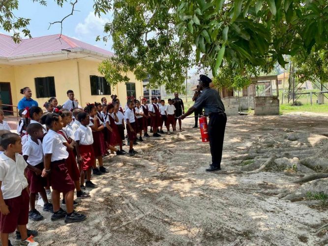 A Guyana Fire Service rank instructing the pupils of Hururu Primary in fire safety awareness 