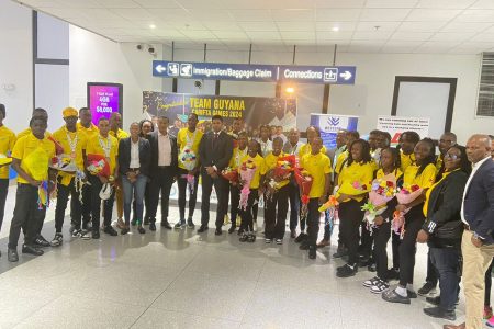 Minister of Culture, Youth, and Sports, Charles Ramson Jr., along with other NSC officials, pose with the returning Carifta Games contingent at the CJIA
