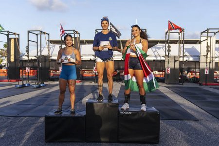 Bryleigh Hansen (centre) of the United States of America is
flanked by Suriname’s Ava Zalman (right) and Heather Dudson
of the USA after winning the Women’s Rx division.