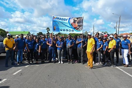 Minister Joseph Hamilton poses with the Massy contingent during Sunday’s walk (DPI photo)
