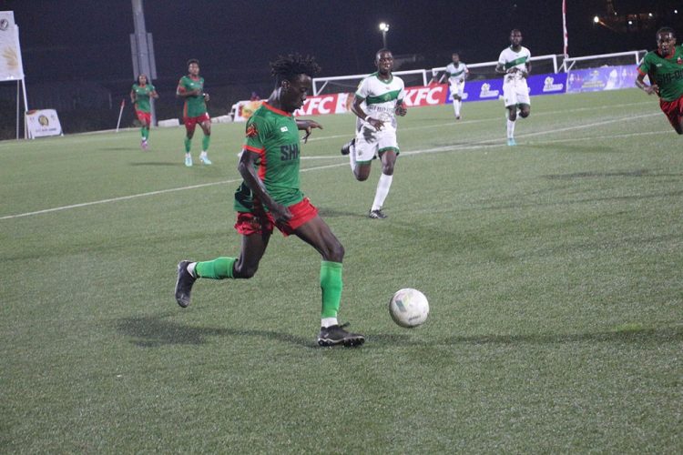 Simeon Moore (centre) of Slingerz on the attack against Den Amstel