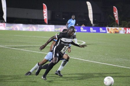 Stephon Reynolds (centre) of Santos on the attack while being pursued by an Anns Grove player
