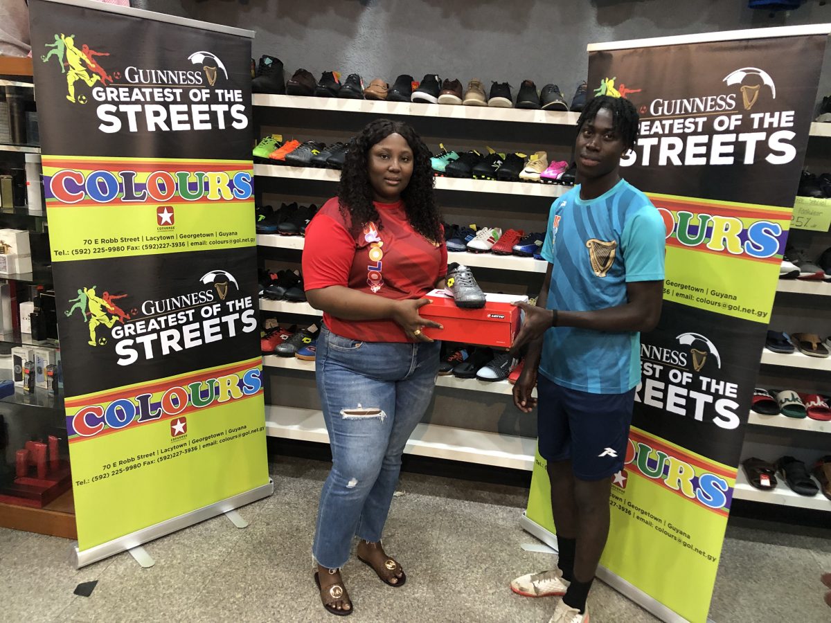 Laing Avenue’s Bevney Mark, the MVP of the Guinness ‘Greatest of the Streets’ Georgetown Championship, receives his prize from Safisha Hope, Supervisor of Colours Boutique