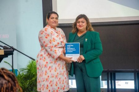 Minister of Education, Priya Manickchand (right) being presented with a copy of the action plan by the Director of Non-communicable Diseases and Mental Health Programme, Latchmie Lall (DPI photo)