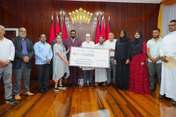 The handing over of the cheque: President Irfaan Ali is eighth from right and United Nations Resident Coordinator in Guyana, Yeşim Oruç is fourth from left. (Office of the President photo)
