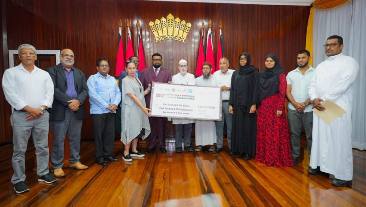 The handing over of the cheque: President Irfaan Ali is eighth from right and United Nations Resident Coordinator in Guyana, Yeşim Oruç is fourth from left. (Office of the President photo)