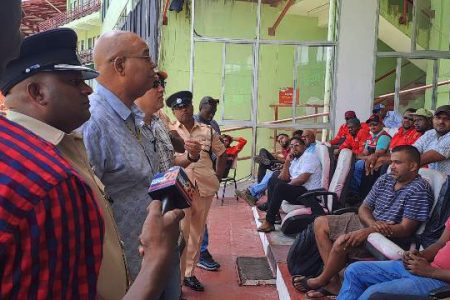 Minister of Public Works Juan Edghill along with police officers seen addressing truck drivers yesterday at the National Stadium where he cautioned them about speeding on the country’s roadways (DPI photo)