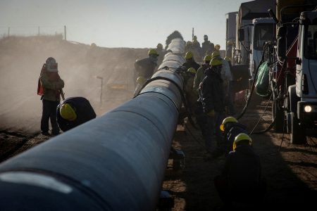 FILE PHOTO: Workers are pictured during the construction of the Nestor Kirchner gas pipeline, which first stage was inaugurated on Sunday to transport natural gas from the Vaca Muerta formation in western Argentina to the province of Santa Fe, passing through the province of Buenos Aires, in Macachin, La Pampa, Argentina April 26, 2023. REUTERS/Martin Cossarini/File Photo