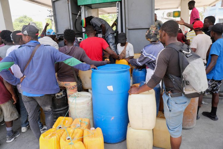 FILE PHOTO: People gather to buy gasoline at a petrol station as violence spreads and armed gangs expand their control over the capital, in Port-au-Prince, Haiti March 29, 2024. REUTERS/Ralph Tedy Erol/File Photo