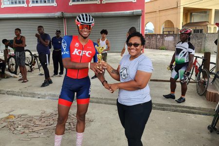 KFC Evolution cyclist Christopher 'Chicken Legs' Griffith receives his Category 1-3 winners trophy from GCF Secretary Carina Westford.