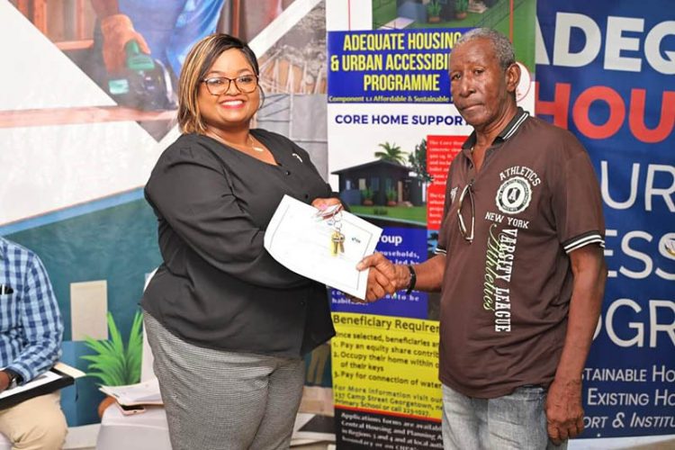 A beneficiary (right) receiving the keys to his home (CH&PA photo)
