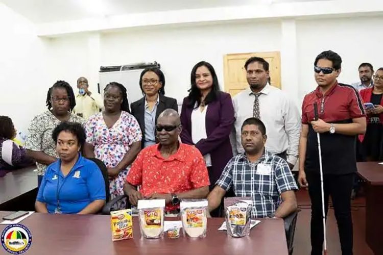 Minister of Human Services and Social Security, Dr Vindhya Persaud (standing fourth from left), and Minister of Tourism, Industry and Commerce, Oneidge Walrond (standing third from left) with recipients of the small business loans. (DPI photo)