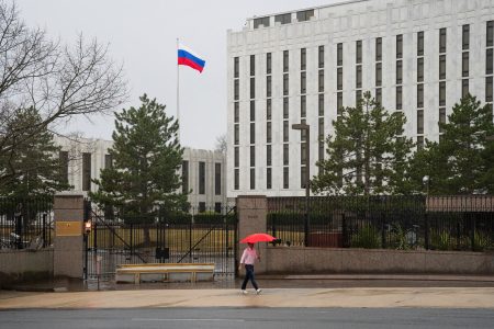FILE PHOTO: A pedestrian walks with an umbrella outside the Embassy of the Russian Federation, near the Glover Park neighborhood of Washington, U.S., February 22, 2022. REUTERS/Tom Brenner