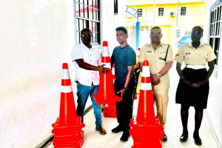 Ritesh Singh (second from left), proprietor of Bardon Construction, donated sixty traffic cones to Region #3 Traffic Department in Thursday last, a release from the police said yesterday.
Commander Regional Police Division #3 Assistant Commissioner Mahendra Siwnarine (left) received the donation from Singh. Commander Siwnarine was accompanied by Assistant Superintendent Maniram Jagnanan, the Officer in Charge of Traffic in Region #3.  (Police photo)
