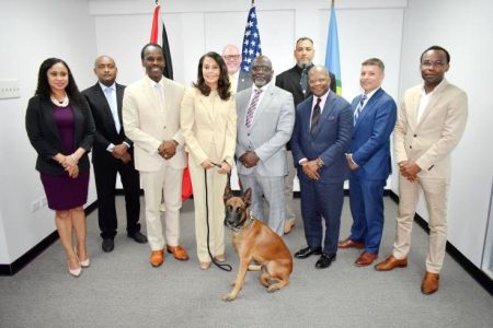 Attendees of the IMPACS meeting in Port-of-Spain posing with the donated sniffer dog