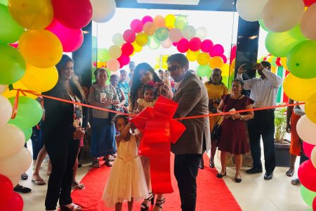 The Puran family cutting the ribbon to open the new outlet
