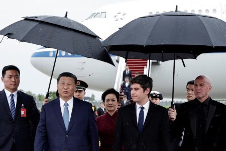 France's Prime Minister Gabriel Attal, China's President Xi Jinping and his wife Peng Liyuan walk under umbrellas upon their arrival for an official two-day state visit, at Orly airport, south of Paris on May 5, 2024. Chinese President Xi Jinping arrived in France on May 5, 2024, for a state visit hosted by Emmanuel Macron where the French leader will seek to push his counterpart on issues. (Reuters photo)