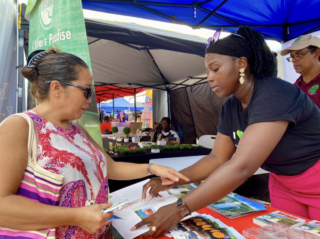The Linden Town Week Business Exposition got underway yesterday with support from the Guyana Tourism Authority (GTA). In this photograph a visitor points to one of the GTA’s brochure while being supported by a staff member. (GTA photo)