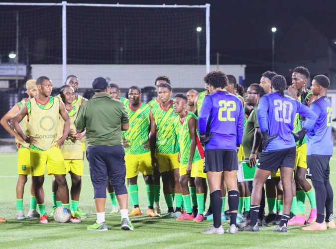 Head coach Jamaal Shabazz (green) makes a point to his charges during a training session at the National Track and Field Centre, Leonora.