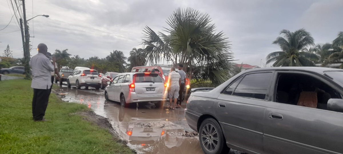 A car stuck in the sink hole that was created by the trucks
