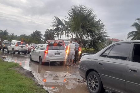 A car stuck in the sink hole that was created by the trucks
