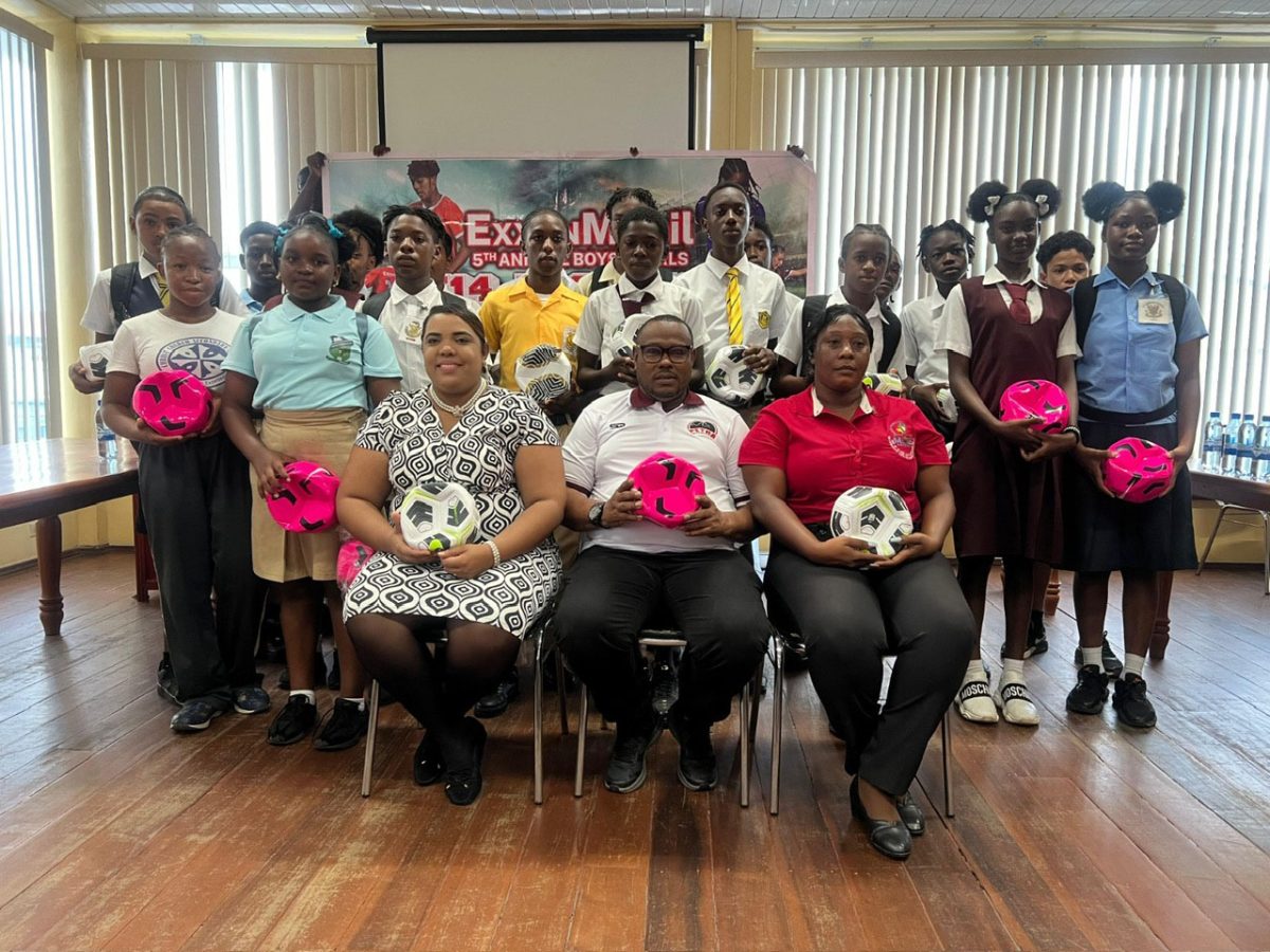 Representatives from the competing teams display their balls that will be used in their preparation for the ExxonMobil Boy’s and Girl’s U-14 Football Championship. Also in the photo are Petra Organisation’s Co-Director Troy Mendonca (sitting-centre) and Towanna McAlmont (sitting-right), representative of the Allied Arts Department of the Ministry of Education.
