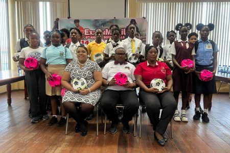 Representatives from the competing teams display their balls that will be used in their preparation for the ExxonMobil Boy’s and Girl’s U-14 Football Championship. Also in the photo are Petra Organisation’s Co-Director Troy Mendonca (sitting-centre) and Towanna McAlmont (sitting-right), representative of the Allied Arts Department of the Ministry of Education.
