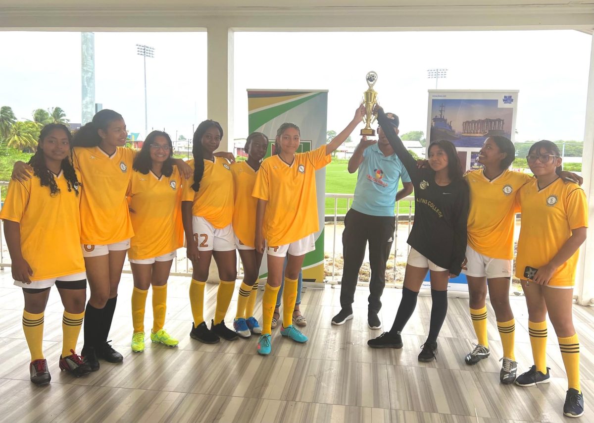 Queen’s College displays its championship after winning the north zone of the Georgetown division