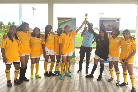 Queen’s College displays its championship after winning the north zone of the Georgetown division