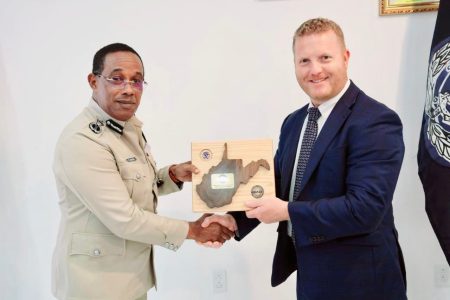 Commissioner of Police Clifton Hicken (left) receiving a token from a member of the team (Police photo)
