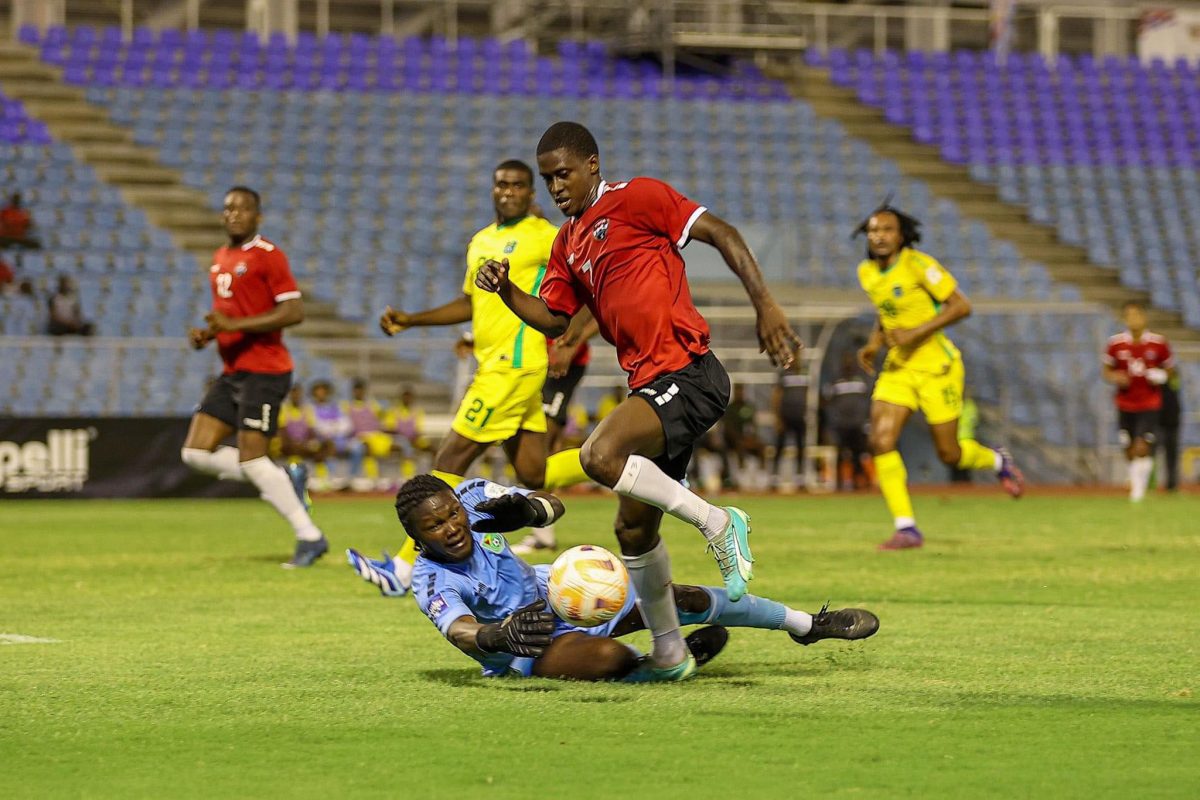 Golden Jaguars goalkeeper Jamaine Cumberbatch attempts
to thwart Isaiah Lee of the Soca Warriors (TTFA photo).