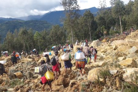 People carry bags in the aftermath of a landslide in Enga Province, Papua New Guinea, May 24, 2024, in this still image obtained from a video. Andrew Ruing/Handout via REUTERS