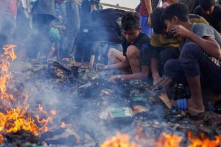 Palestinians search for food among burnt debris in the aftermath of an Israeli strike on an area designated for displaced people in Rafah, in the southern Gaza Strip, on May 27, 2024. (Photo: REUTERS/Mohammed Salem)
