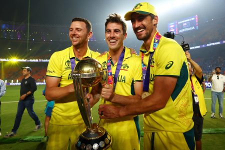 FILE PHOTO: Cricket - ICC Cricket World Cup 2023 - Final - India v Australia - Narendra Modi Stadium, Ahmedabad, India - November 19, 2023 Australia's Josh Hazlewood, Pat Cummins and Mitchell Starc celebrate with the trophy after winning the ICC Cricket World Cup REUTERS/Andrew Boyers/File Photo