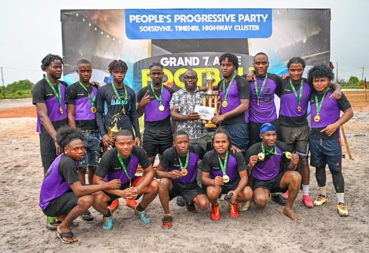 Kuru Kururu ‘A’ Captain, Shervin Henry receives the top prize and trophy from Hon. Minister Kwame McKoy in the presence of his teammate on Sunday afternoon at the Kuru Kuru Ground. 