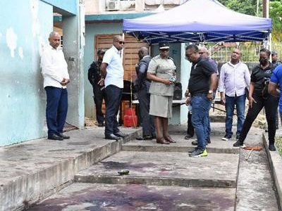 Police Commissioner Erla Harewood-Christopher watches the blood-stained area where four people were murdered at Powder Magazine, Cocorite on Saturday night. Photo ISHMAEL SALANDY.