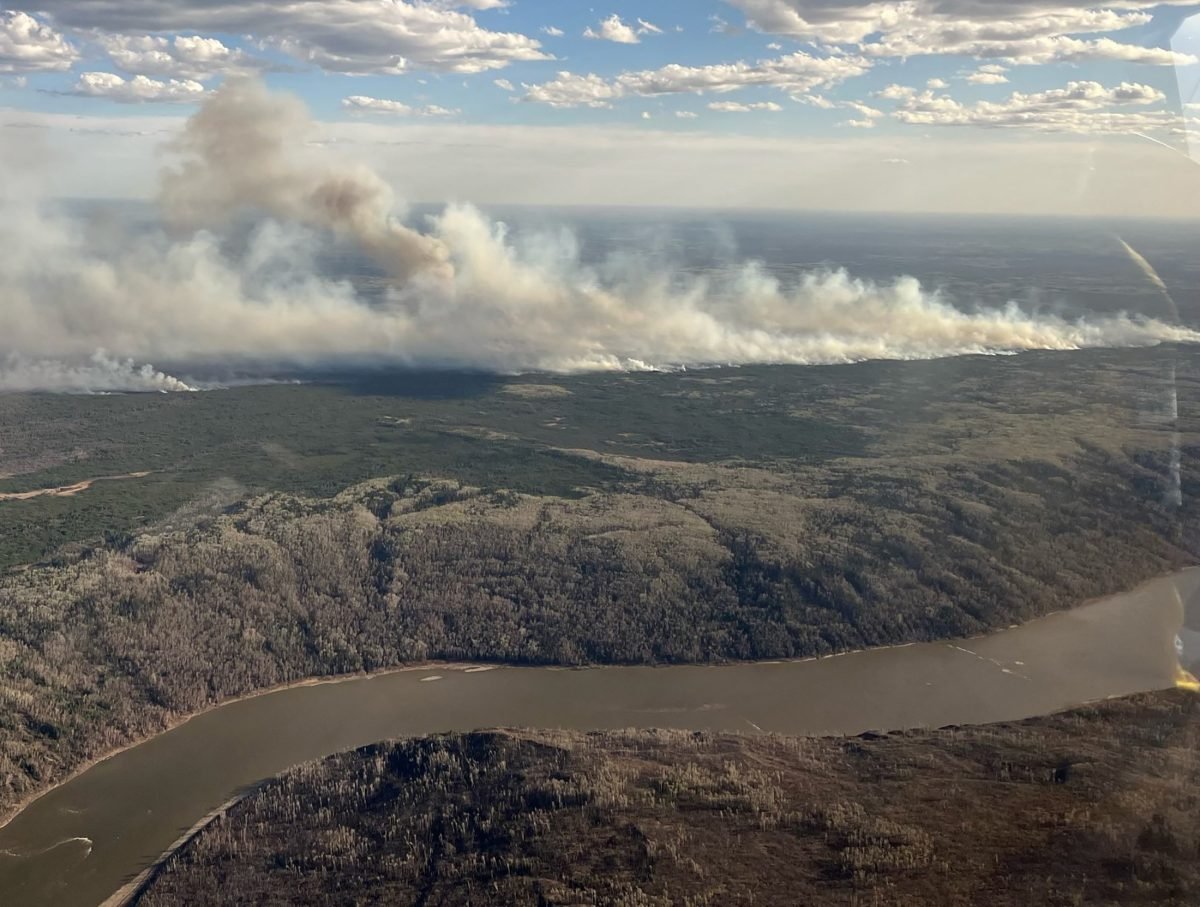 A picture taken through a window shows smoke rising from wildfire MWF017 on the south side of the Athabasca River valley near Fort McMurray, Alberta, Canada May 10, 2024. Alberta Wildfire/Handout via REUTERS