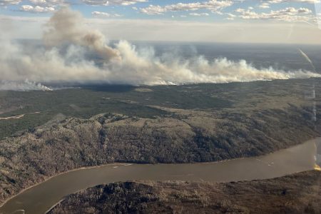 A picture taken through a window shows smoke rising from wildfire MWF017 on the south side of the Athabasca River valley near Fort McMurray, Alberta, Canada May 10, 2024. Alberta Wildfire/Handout via REUTERS